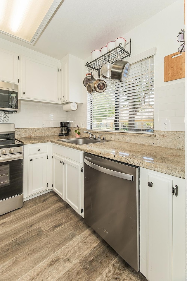 4885 N Backer Ave Unit 113, Fresno, CA 93726 - kitchen featuring stainless steel appliances, decorative backsplash, wood finished floors, and white cabinets