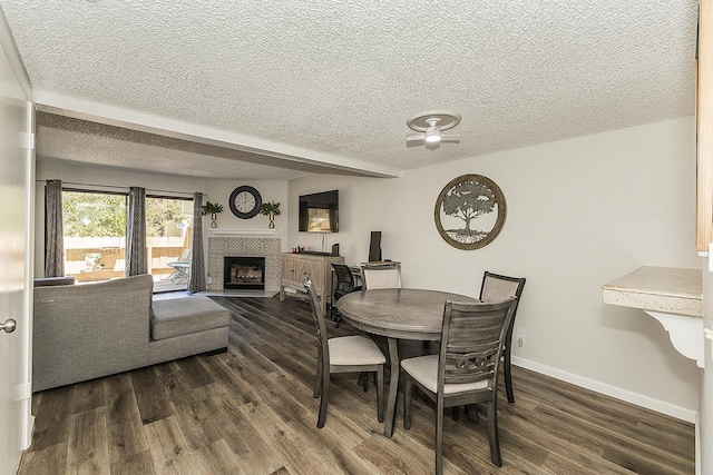 4885 N Backer Ave Unit 113, Fresno, CA 93726 - dining room with a textured ceiling, dark wood-type flooring, and a tile fireplace