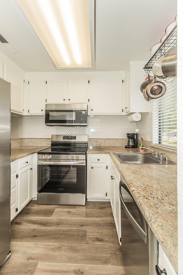 4885 N Backer Ave Unit 113, Fresno, CA 93726 - kitchen with appliances with stainless steel finishes, white cabinetry, and wood finished floors