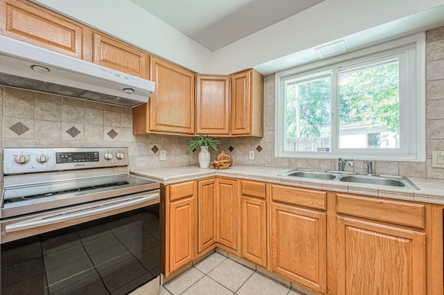 545 W Fedora Ave, Fresno, CA 93705 - kitchen featuring stainless steel electric range oven, range hood, light tile patterned flooring, tasteful backsplash, and tile counters