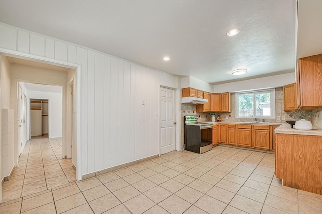 545 W Fedora Ave, Fresno, CA 93705 - kitchen featuring electric stove, light countertops, under cabinet range hood, light tile patterned flooring, and wood walls