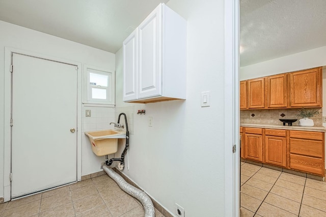 545 W Fedora Ave, Fresno, CA 93705 - laundry area featuring hookup for an electric dryer, cabinet space, and light tile patterned floors