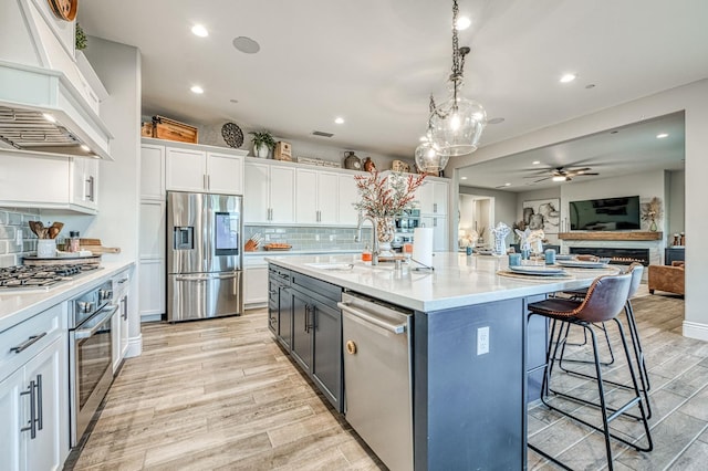 924 Orchard Hills Rd, Madera, CA 93636 - kitchen featuring appliances with stainless steel finishes, premium range hood, white cabinets, a ceiling fan, and light countertops