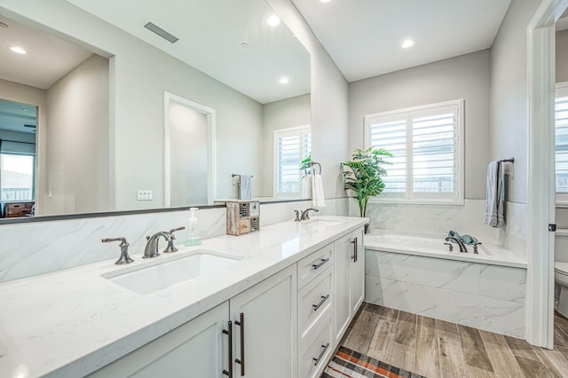 924 Orchard Hills Rd, Madera, CA 93636 - bathroom featuring double vanity, a garden tub, wood finished floors, and recessed lighting