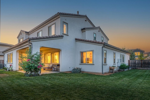 924 Orchard Hills Rd, Madera, CA 93636 - back of property at dusk with a tiled roof, a patio area, and stucco siding
