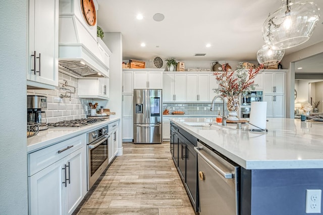 924 Orchard Hills Rd, Madera, CA 93636 - kitchen with stainless steel appliances, premium range hood, white cabinets, tasteful backsplash, and recessed lighting