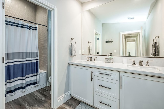 924 Orchard Hills Rd, Madera, CA 93636 - bathroom with double vanity, shower / bath combo with shower curtain, and wood finished floors