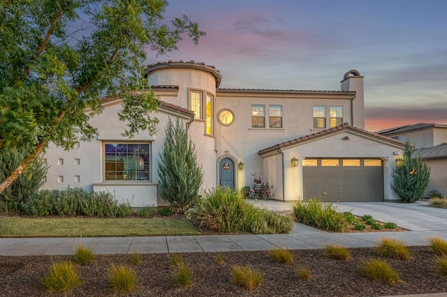 924 Orchard Hills Rd, Madera, CA 93636 - mediterranean / spanish house featuring an attached garage, driveway, stucco siding, and a chimney