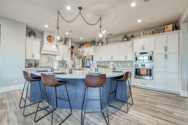 924 Orchard Hills Rd, Madera, CA 93636 - kitchen with decorative backsplash, light countertops, light wood-style flooring, white cabinetry, and recessed lighting