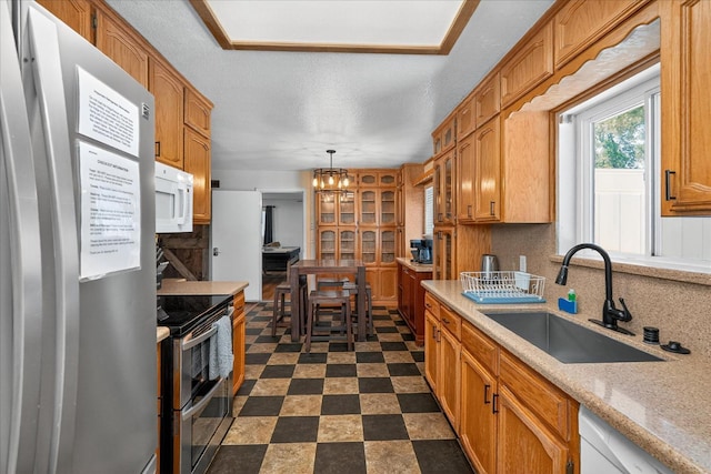 53401 Timberview Rd, North Fork, CA 93643 - kitchen with appliances with stainless steel finishes, light countertops, glass insert cabinets, tasteful backsplash, and hanging light fixtures