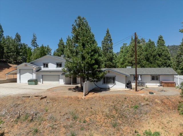 53401 Timberview Rd, North Fork, CA 93643 - view of front facade featuring concrete driveway, a hot tub, an attached garage, and a shingled roof