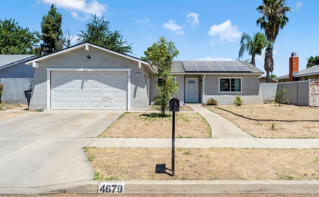4679 E Pitt Ave, Fresno, CA 93725 - ranch-style home featuring stucco siding, roof mounted solar panels, driveway, and an attached garage