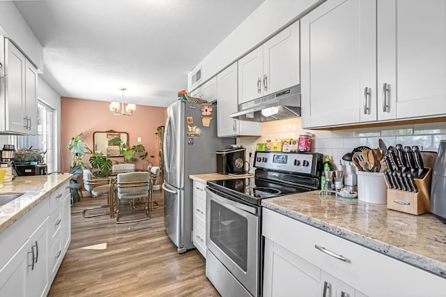 4679 E Pitt Ave, Fresno, CA 93725 - kitchen with appliances with stainless steel finishes, under cabinet range hood, backsplash, white cabinets, and a chandelier