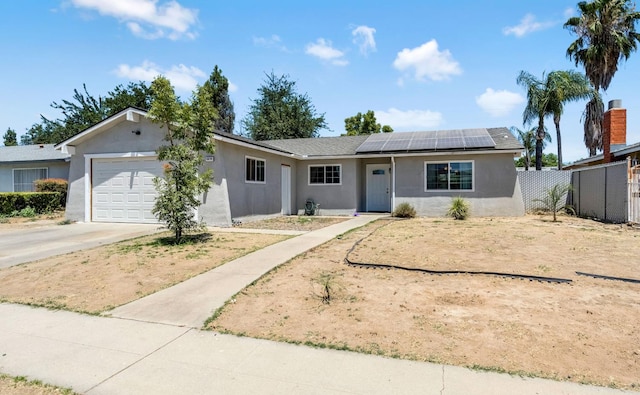 4679 E Pitt Ave, Fresno, CA 93725 - single story home with stucco siding, an attached garage, solar panels, and concrete driveway