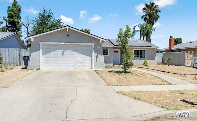 4679 E Pitt Ave, Fresno, CA 93725 - ranch-style house with stucco siding, solar panels, concrete driveway, a garage, and a gate