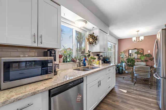4679 E Pitt Ave, Fresno, CA 93725 - kitchen featuring appliances with stainless steel finishes, decorative backsplash, white cabinets, and a chandelier