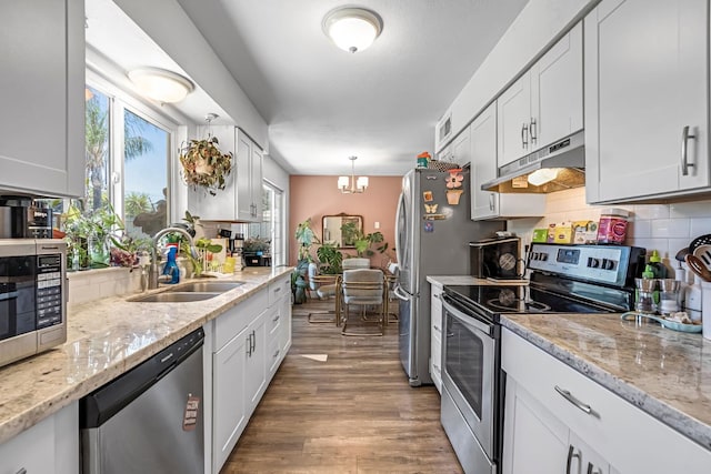 4679 E Pitt Ave, Fresno, CA 93725 - kitchen featuring appliances with stainless steel finishes, under cabinet range hood, wood finished floors, and healthy amount of natural light