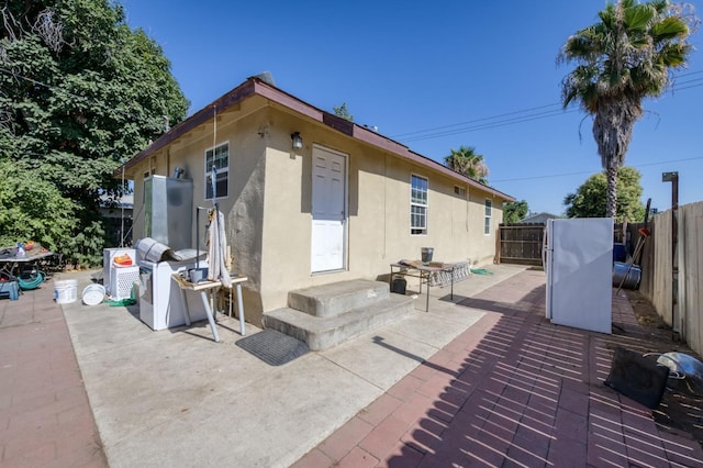 448 E Tuolumne St, Fresno, CA 93706 - rear view of property with stucco siding, a fenced backyard, and a patio