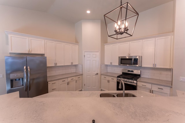 1963 Rialto Ct, Clovis, CA 93611 - kitchen featuring stainless steel appliances, white cabinets, a chandelier, decorative backsplash, and recessed lighting