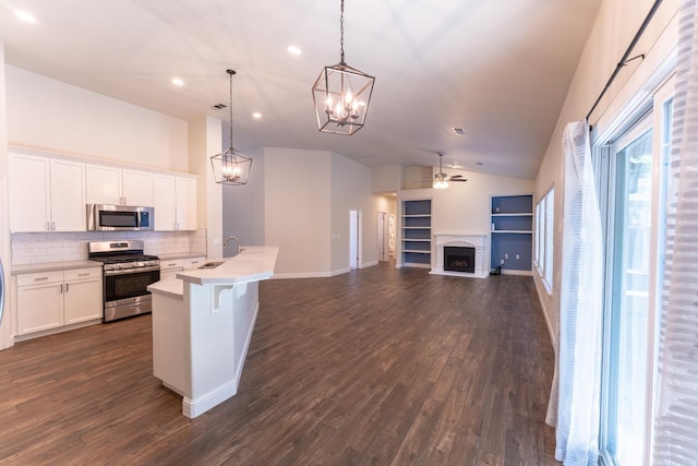 1963 Rialto Ct, Clovis, CA 93611 - kitchen with appliances with stainless steel finishes, a fireplace, lofted ceiling, decorative backsplash, and a ceiling fan