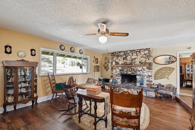 44810 Douglas Rd S, Coarsegold, CA 93614 - living area with ceiling fan, wood finished floors, a textured ceiling, and a stone fireplace