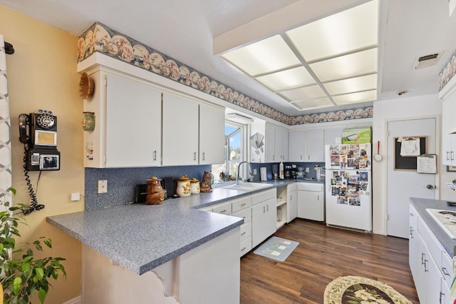 44810 Douglas Rd S, Coarsegold, CA 93614 - kitchen with white appliances, a peninsula, tasteful backsplash, dark wood-type flooring, and white cabinetry