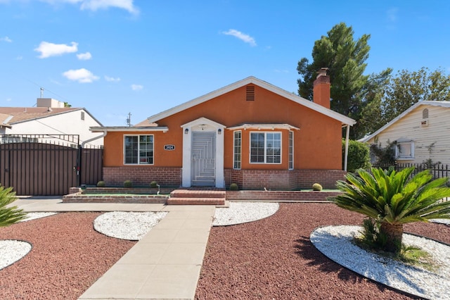 3924 E Iowa Ave, Fresno, CA 93702 - bungalow-style house with brick siding, a gate, a chimney, and stucco siding
