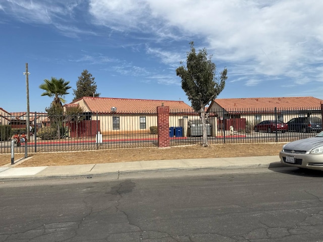 1405 E Cypress Ave Unit 137, Reedley, CA 93654 - view of front of house with a tiled roof and a fenced front yard