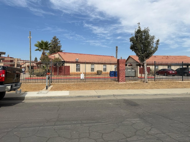 1405 E Cypress Ave Unit 137, Reedley, CA 93654 - view of front of home with a tile roof and a fenced front yard