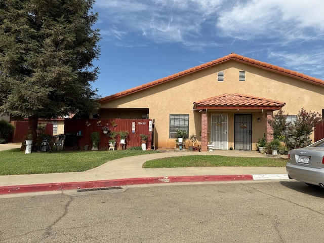 1405 E Cypress Ave Unit 217, Reedley, CA 93654 - mediterranean / spanish house featuring stucco siding, a tile roof, and a front yard