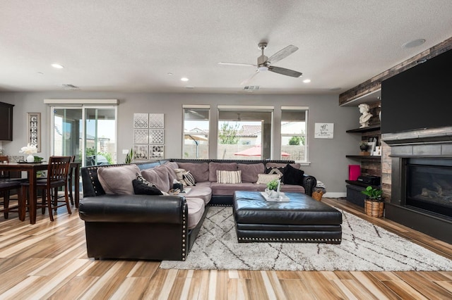 1397 N Redington Ave, Clovis, CA 93619 - living area with light wood-style floors, recessed lighting, a textured ceiling, a ceiling fan, and a fireplace