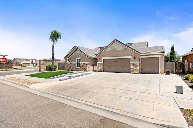 1397 N Redington Ave, Clovis, CA 93619 - craftsman house featuring a garage, stone siding, stucco siding, driveway, and a tiled roof