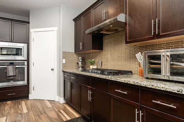 1397 N Redington Ave, Clovis, CA 93619 - kitchen with appliances with stainless steel finishes, under cabinet range hood, tasteful backsplash, and light stone countertops