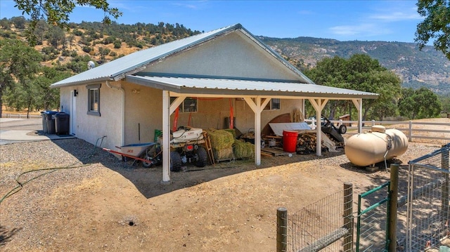 34503 Backbone Rd, Auberry, CA 93602 - view of home's exterior featuring stucco siding, a mountain view, and a metal roof