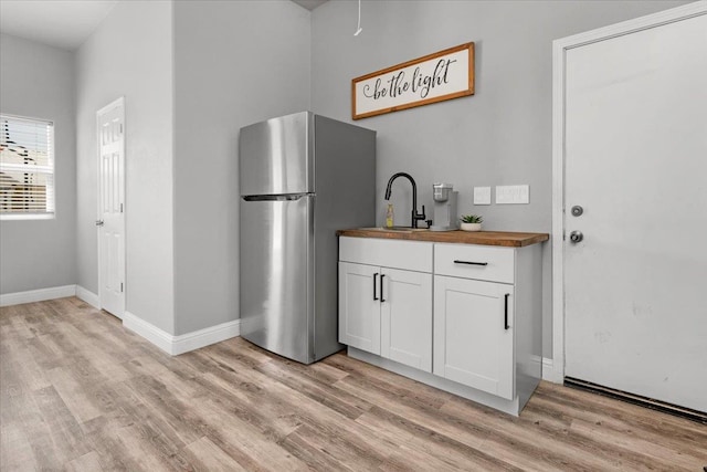 34503 Backbone Rd, Auberry, CA 93602 - kitchen with freestanding refrigerator, wood counters, light wood finished floors, and white cabinets