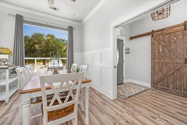 34503 Backbone Rd, Auberry, CA 93602 - dining space with ornamental molding, light wood finished floors, a barn door, and a wainscoted wall