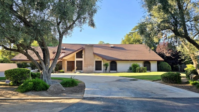5433 E Geary St, Fresno, CA 93727 - view of front of home with stucco siding, a tiled roof, a front lawn, and curved driveway