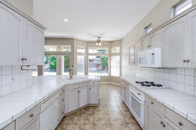 5484 W El Paso Ave, Fresno, CA 93722 - kitchen featuring white appliances, tile countertops, healthy amount of natural light, and recessed lighting