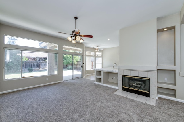 5484 W El Paso Ave, Fresno, CA 93722 - unfurnished living room featuring light colored carpet, a ceiling fan, a tile fireplace, and recessed lighting