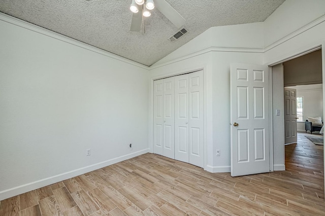 6355 N Cleo Ave, Fresno, CA 93722 - unfurnished bedroom with vaulted ceiling, light wood-style floors, a closet, a ceiling fan, and a textured ceiling