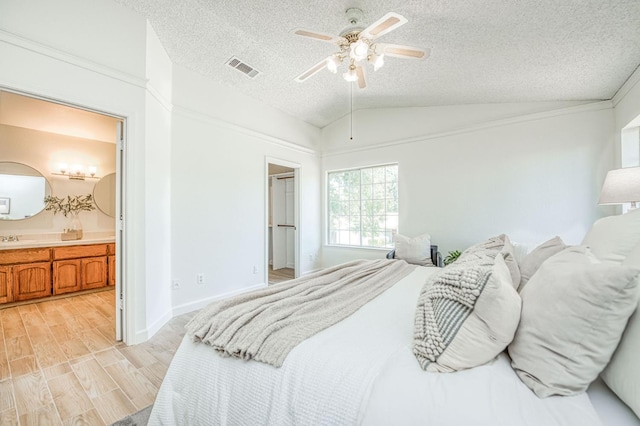 6355 N Cleo Ave, Fresno, CA 93722 - bedroom with lofted ceiling, a textured ceiling, light wood-type flooring, ensuite bath, and a ceiling fan