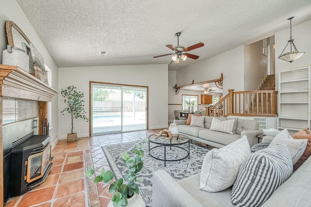 6355 N Cleo Ave, Fresno, CA 93722 - living room featuring a ceiling fan, stairs, a wood stove, a textured ceiling, and lofted ceiling
