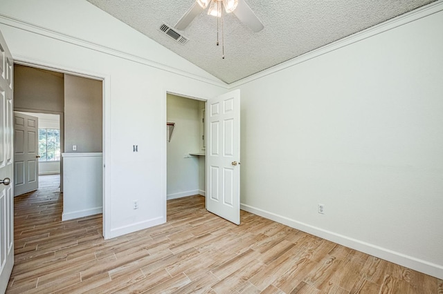 6355 N Cleo Ave, Fresno, CA 93722 - unfurnished bedroom featuring lofted ceiling, light wood-type flooring, a textured ceiling, and ceiling fan
