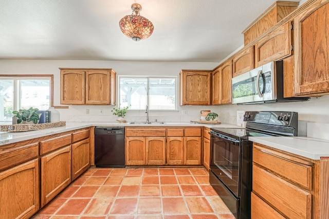 6355 N Cleo Ave, Fresno, CA 93722 - kitchen featuring black appliances, brown cabinetry, and light countertops