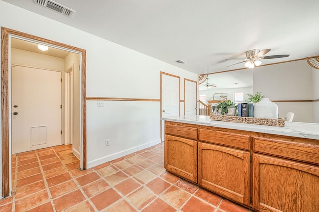 6355 N Cleo Ave, Fresno, CA 93722 - kitchen featuring ceiling fan, light countertops, and brown cabinets