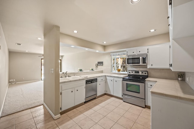 1702 W Bullard Unit 105, Fresno, CA 93711 - kitchen featuring stainless steel appliances, light tile patterned floors, white cabinets, tile counters, and recessed lighting