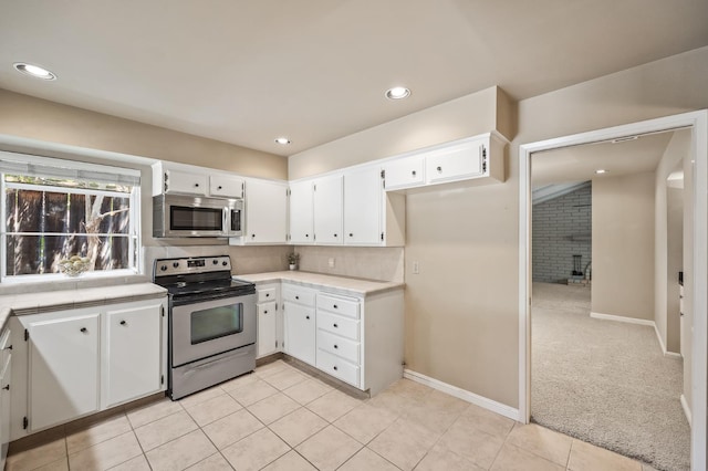 1702 W Bullard Unit 105, Fresno, CA 93711 - kitchen with appliances with stainless steel finishes, white cabinets, light tile patterned flooring, backsplash, and recessed lighting