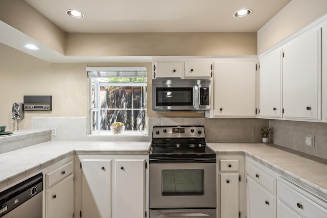 1702 W Bullard Unit 105, Fresno, CA 93711 - kitchen featuring appliances with stainless steel finishes, white cabinetry, tasteful backsplash, and recessed lighting