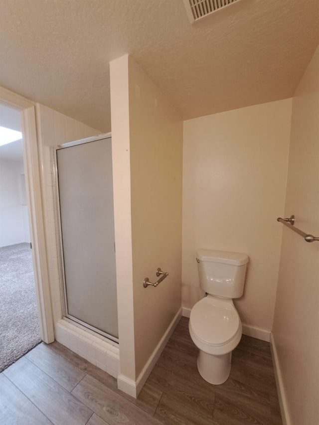 4919 N Millbrook Ave Unit 123, Fresno, CA 93726 - full bathroom featuring wood finished floors, a shower stall, and a textured ceiling