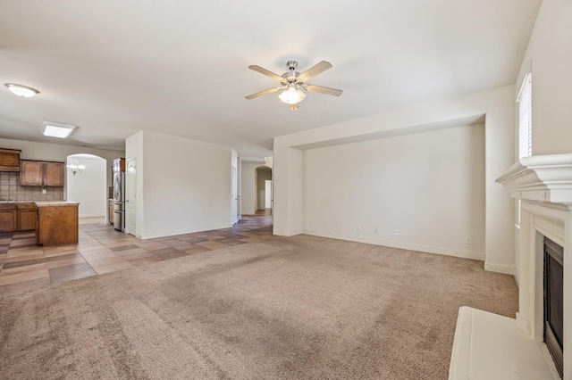 5929 N La Paz Ave, Fresno, CA 93723 - unfurnished living room featuring arched walkways, light colored carpet, a ceiling fan, a fireplace, and light tile patterned floors